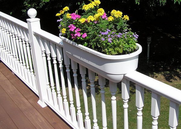 White traditional deck railing with planters. This white deck railing is really ornate but I especially love the planters. The flash of color of flowers give a beautiful look that adds the beauty of your railing. 