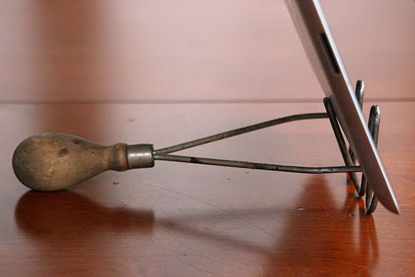 DIY iPad stand out of vintage potato mashers. Simply bend the middle loop on the masher back towards the handle. This simple iPad stand looks great in the kitchen for looking at recipes or reading your favorite blog. 