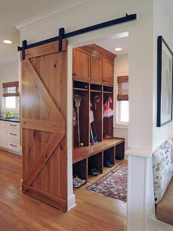 Wood mudroom. I love this area of house very much. It's really adorable with the warm wood color, mudroom view great barn door, wood flooring, boot storage, bench, hooks and expand upper shelf for hats. 