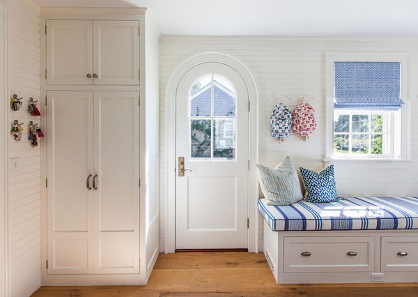 Mediterranean style mudroom with coastal decor. What a cute and functional mud room! The lovely coastal decor complements the classic architectural details. 