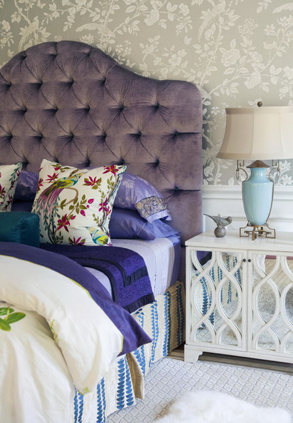 Comfy Luxury: The plush, tufted purple headboard adds comfy luxury to this bedroom. The layered, colorful bedding is an example of how you can inject a subtler dose of purple. The mirrored bedside table looks chic and elegant. 