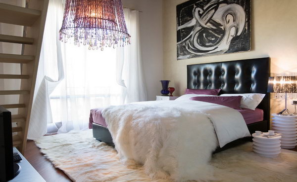 Touches of Purple: This bedroom with a striking chandelier and a leather headboard and the impressive modern wall art really looks rock. Yet the faux animal furs and the touches of purple on the bedding infuse warm and soft. Good example of interpreting purple in different textures 