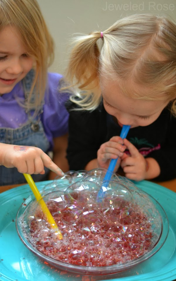  Play with bubbles. Children love to play with colorful bubbles and they would never be bored with this game. All you need is one or two containers, water, dish soap (I used Dawn) and a straw. 