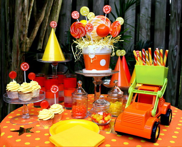 Truck Birthday Decoration: The Dump Truck served as a great decoration and the lollipop bouquet in a bright planter are great. Love the smaller lollipops as cupcake toppers, and glued leftover lollipops to the top of the party hats for some extra pizzazz! Glass cake stands and apothecary jars helped display all the different goodies. 